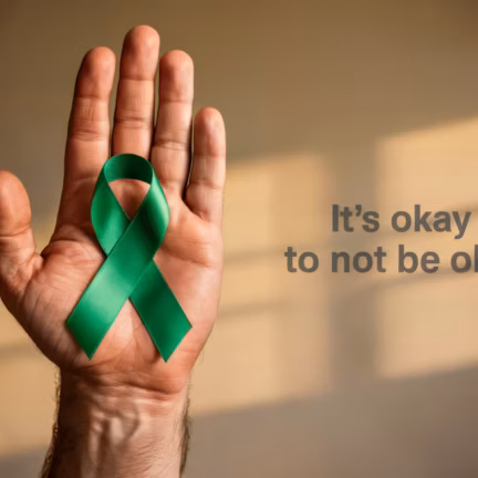 Hand holding a green ribbon symbolizing Men's Mental Health Month, with the message "Men's Mental Health Month" in bold text. The image conveys support and awareness for mental health. Concept of ment Hand holding a green ribbon symbolizing Men's Mental Health Month, with the message "Men's Mental Health Month" in bold text. The image conveys support and awareness for mental health. Concept of ment