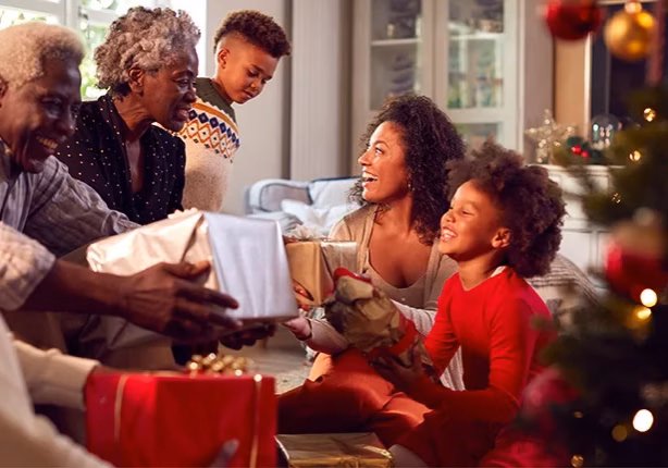 multigeneration family exchanging gifts, smiling and laughing multigeneration family exchanging gifts, smiling and laughing
