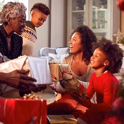 multigeneration family exchanging gifts, smiling and laughing multigeneration family exchanging gifts, smiling and laughing
